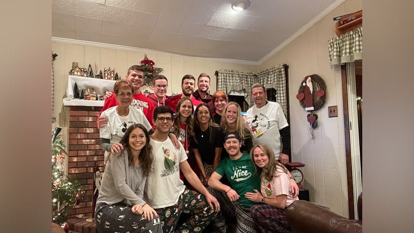 Grandparents Pat and Tony Sindoni smile alongside their 10 grandchildren