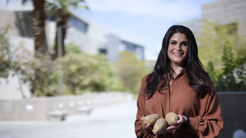 UNLV assistant professor Neda Akhavan, PhD, holds three baked potatoes in her hands.