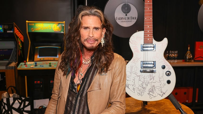 Steven Tyler in front of a guitar