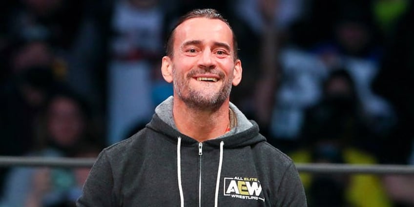 aew star cm punk poses with trans rights are human rights sign at all in event