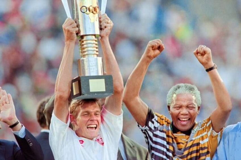 South Africa captain Neil Tovey lifts the Africa Cup of Nations trophy in 1996 as then President Nelson Mandela celebrates.