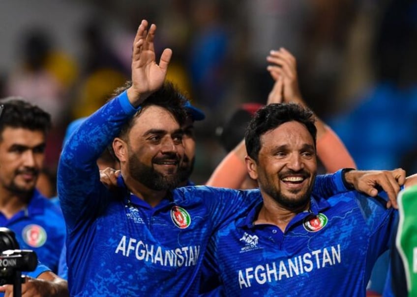 'Massive achievement': Afghanistan captain Rashid Khan (L) and Gulbadin Naib celebrate the
