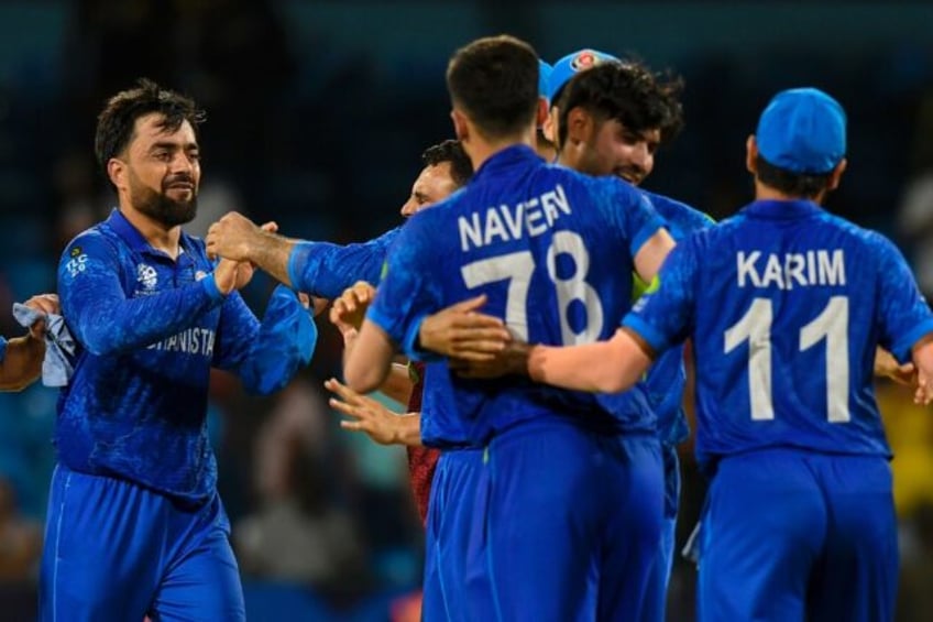 Afghanistan captain Rashid Khan (L) celebrates with his teammates after the 'massive' win