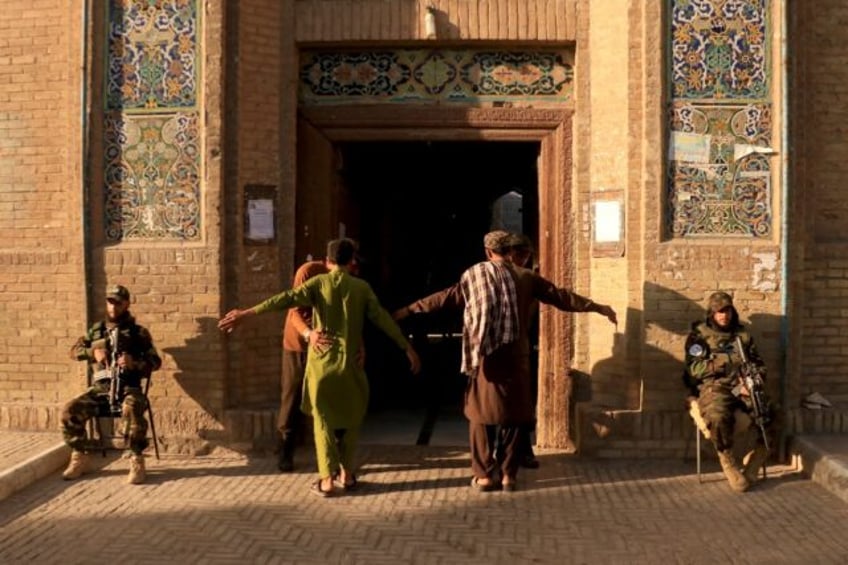 Security personnel frisk devotees entering to offer Eid al-Adha prayers at Jami mosque in