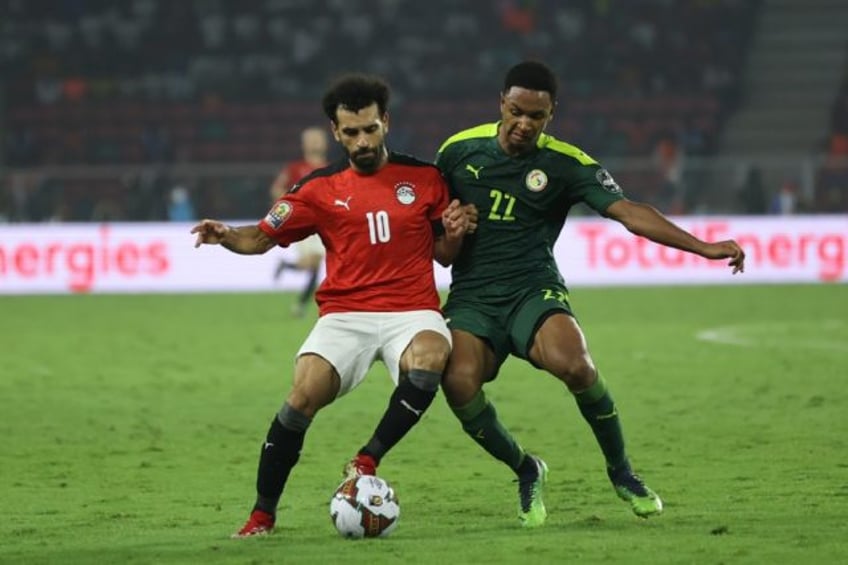 Egypt captain Mohamed Salah (L) tussles for possession with Senegal forward Mame Thiam during the Africa Cup of Nations final in Yaounde on February 6, 2022.