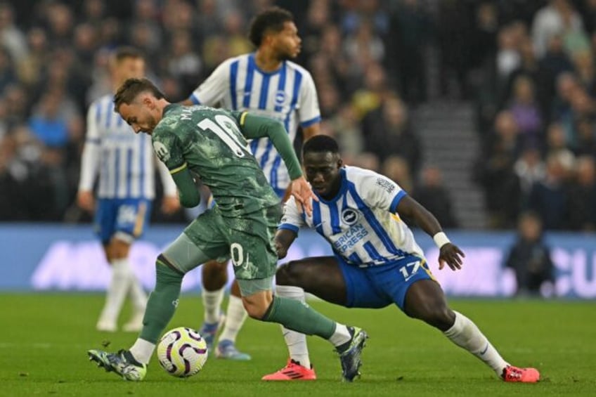 James Maddison (L) of Tottenham Hotspur shields the ball from Yankuba Minteh of Brighton