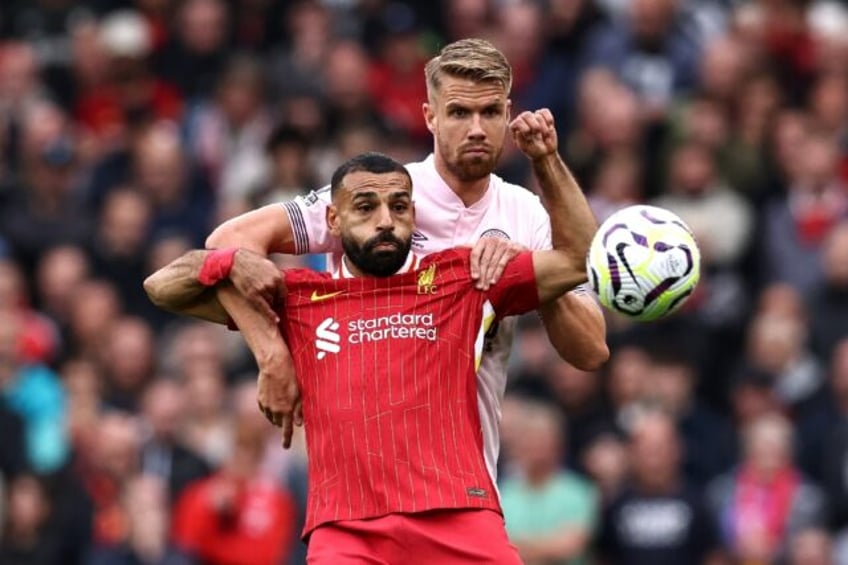 Liverpool scorer Mohamed Salah (L) shields the ball from Brentford defender Kristoffer Aje