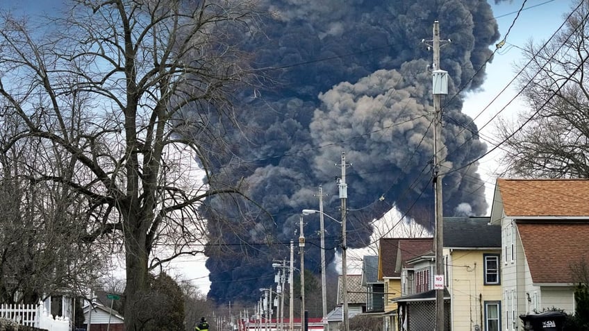 A black plume rises over East Palestine, Ohio, as a result of the controlled detonation of a portion of the derailed Norfolk Southern trains