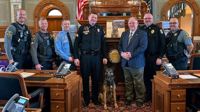 Kansas House Speaker Dan Hawkins poses with law enforcement officers from the Wichita area and Oz, a Wichita police dog
