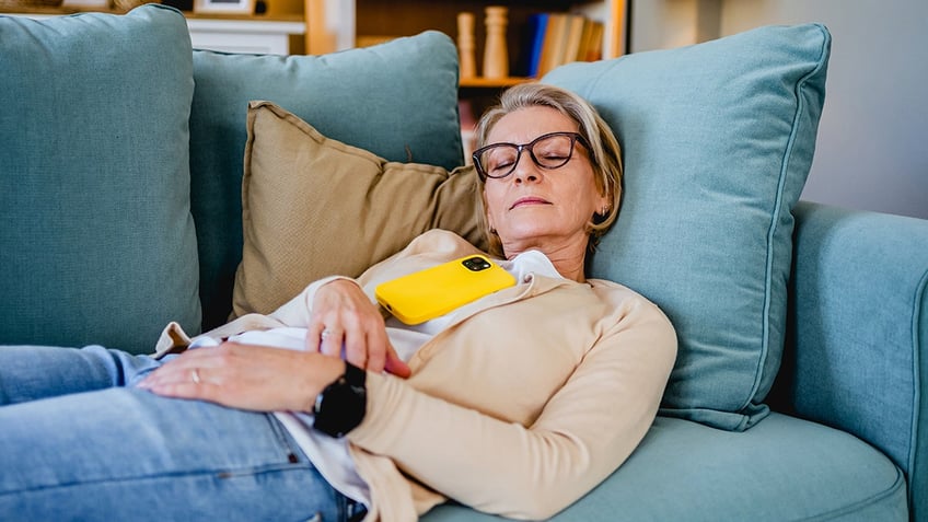 Tired woman taking a nap on the sofa in the living room