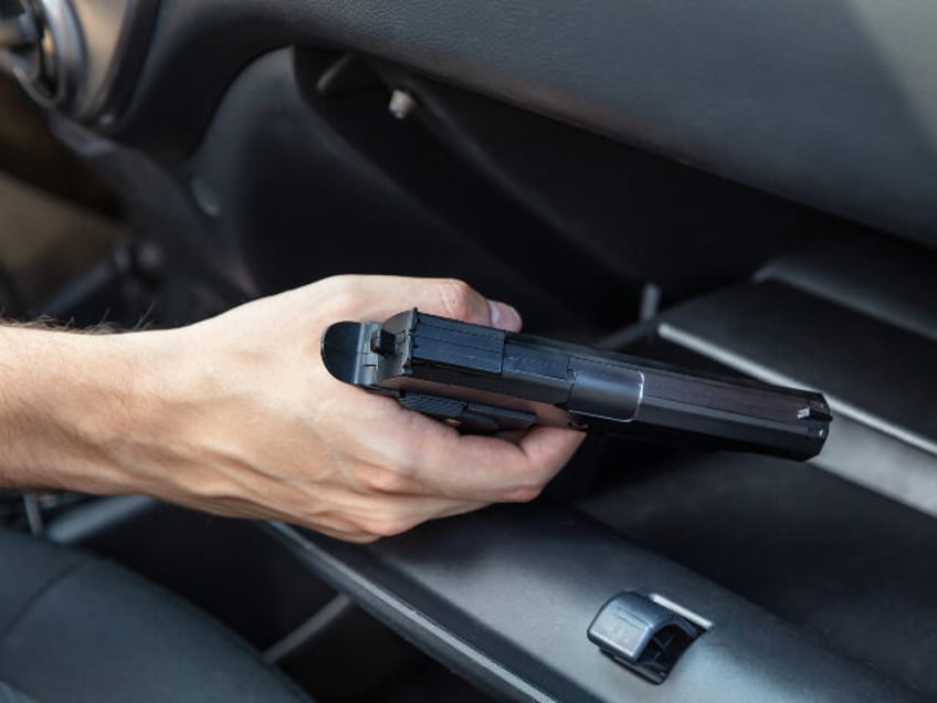 man with gun in car