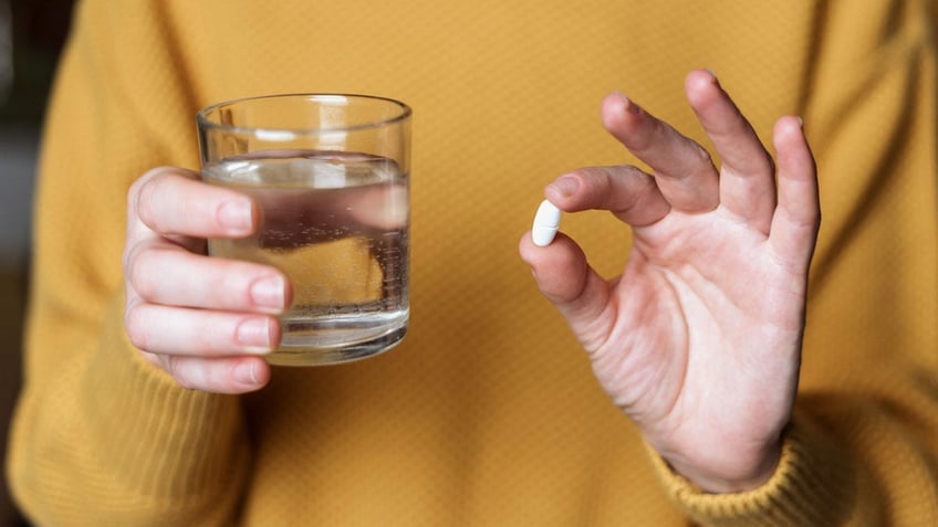 Woman holding pill