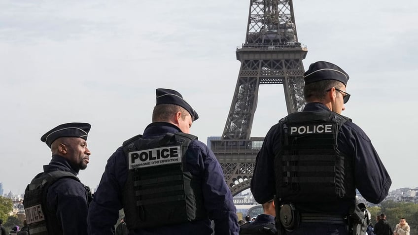 Police officers patrol the Trocadero plaza near the Eiffel Tower in Paris