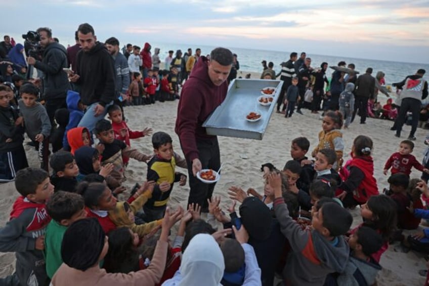 Hamada Shaqura, a former food blogger, distributes food after cooking a meal for displaced