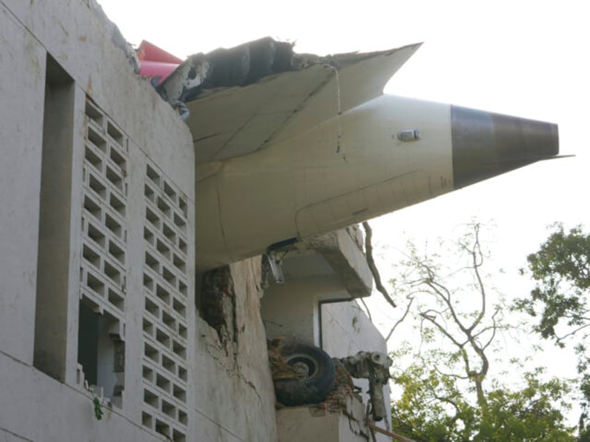 The debris of an airplane sticks out of a building after it crashed in India's northw