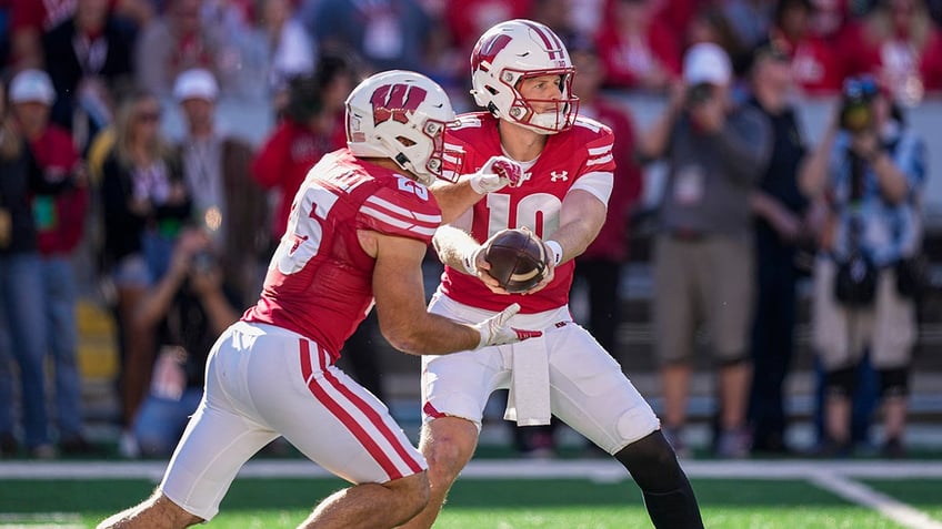 Tyler Van Dyke hands the ball off