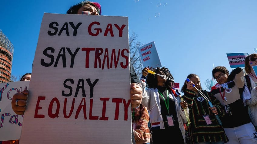 Protestor holds pro-trans care sign during Kentucky protest