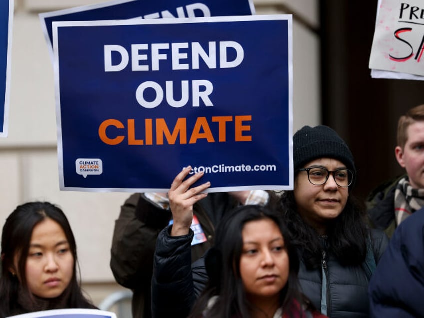 Demonstrators hold signs outside of the Environmental Protection Agency (EPA) headquarters