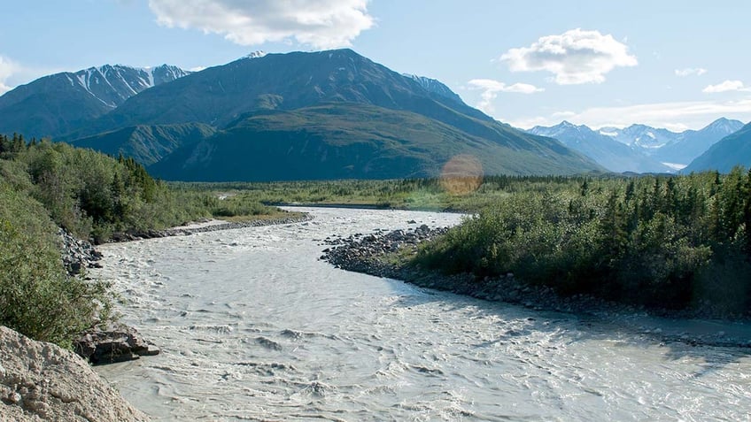 A river in Alaska with a mountain in the background during the day