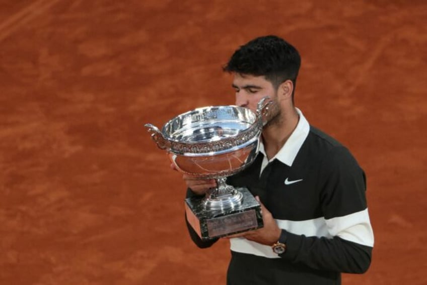 Carlos Alcaraz kisses the Coupe des Mousquetaires after scraping past Jannik Sinner in a t