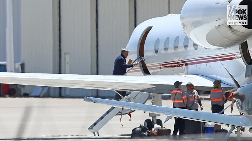 Alec Baldwin gets on a plane