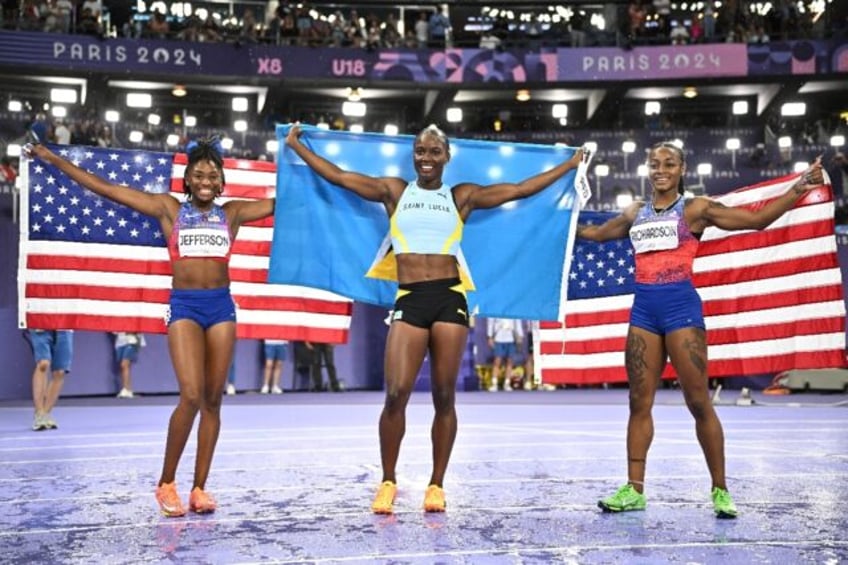 St Lucia's Julien Alfred (C) after winning Olympic 100m gold, with silver medallist Sha'Ca