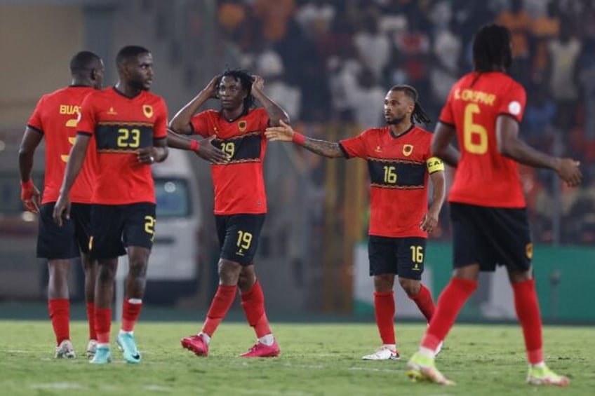 Mabululu, Angola's number 19, celebrates scoring his team's equaliser against Algeria from the penalty spot