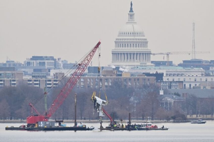 A crane removes wreckage from the Potomac River of American Eagle Flight 5342, which colli