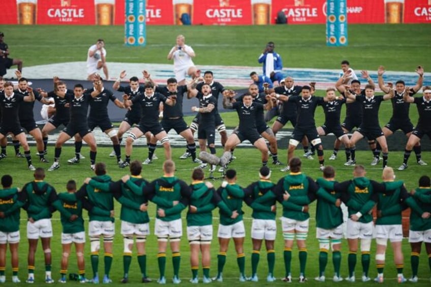 New Zealand players (background) perform the Haka watched by the South African team ahead