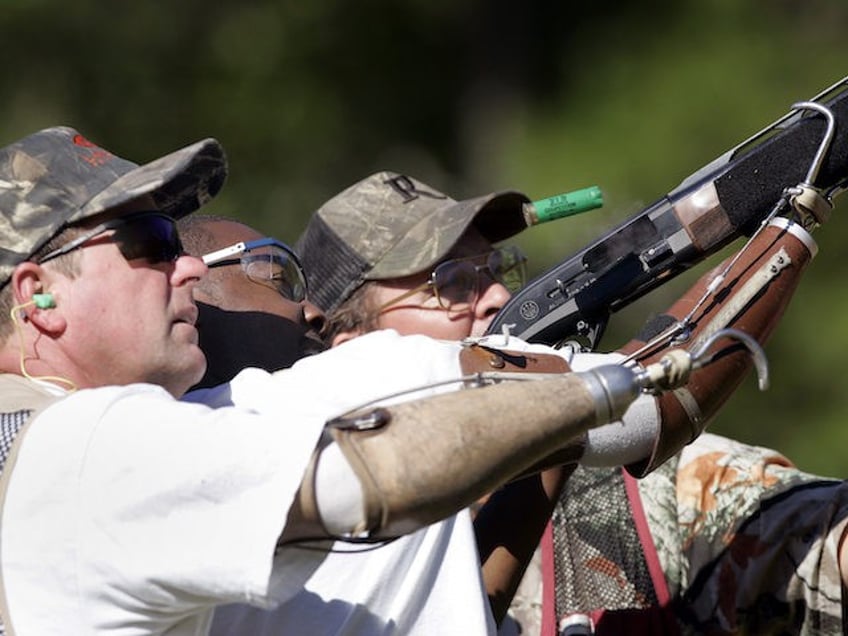 Delvin McMillian, 27, center, of Birmingham, Ala., gets help shooting at clay pigeons with