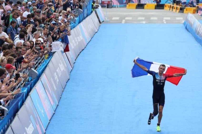 Alexis Hanquinquant celebrates with the French flag as he crosses the finish line to win t