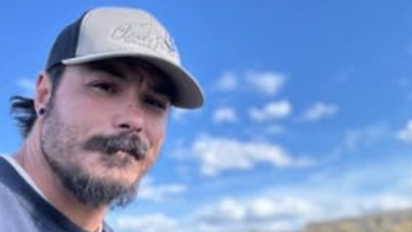 Travis Decker wears a baseball hat