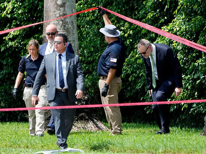 Law enforcement officials work outside of the Trump International Golf Club after the appa