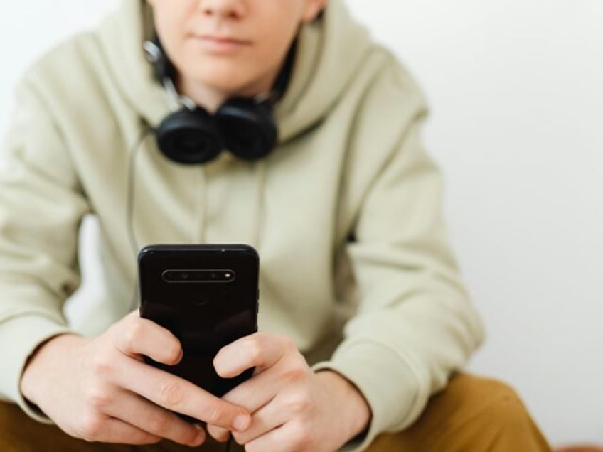 Man in Wearing Hoodie Using a Smartphone