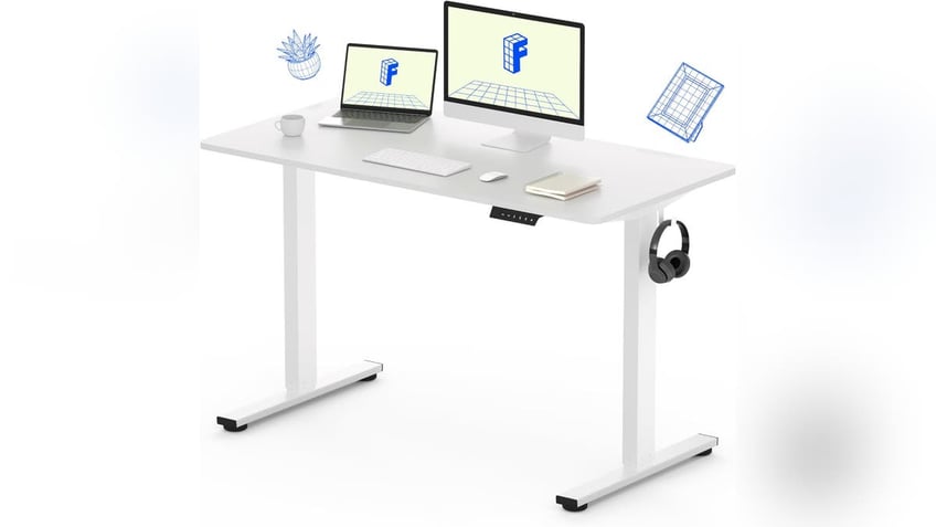 An electric-adjustable desk for standing or sitting.