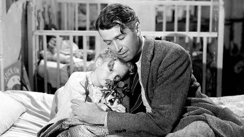 James Stewart embracing Karolyn Grimes.