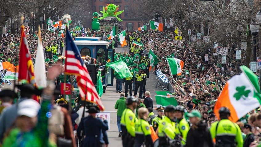 Parade viewers wave flags and cheer on marchers during the annual St. Patrick's Day &amp; Evacuation Day Parade in Boston on March 16, 2025. Evacuation Day commemorates the evacuation of British forces from the city of Boston, early in the American Revolutionary War.