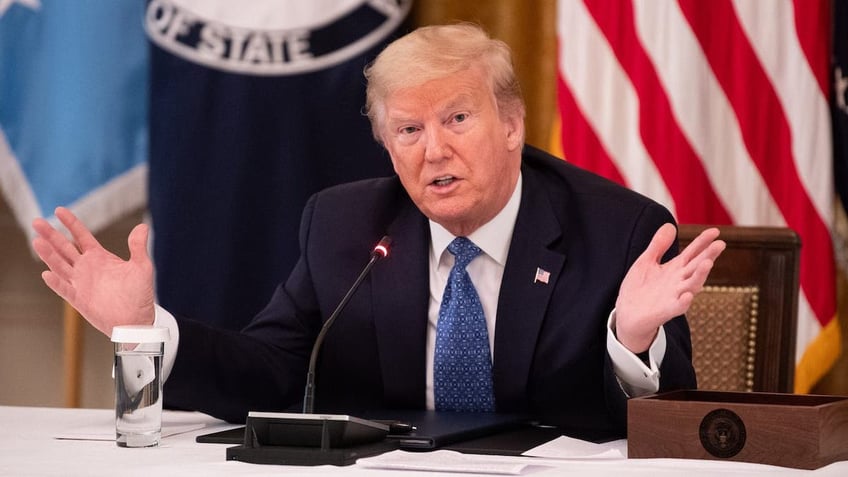 President Donald Trump waves hands