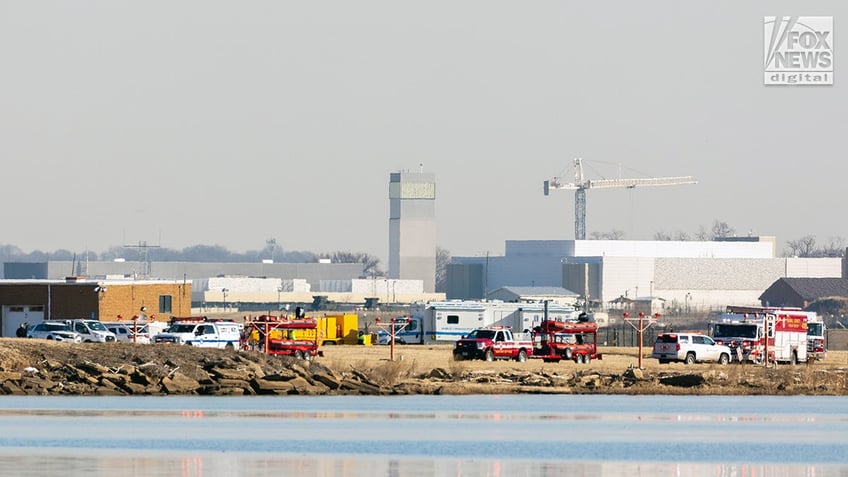 Emergency response units respond to the crash site of an American Airlines plane and Black Hawk helicopter