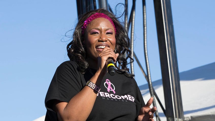 Mandisa singing on stage outdoors