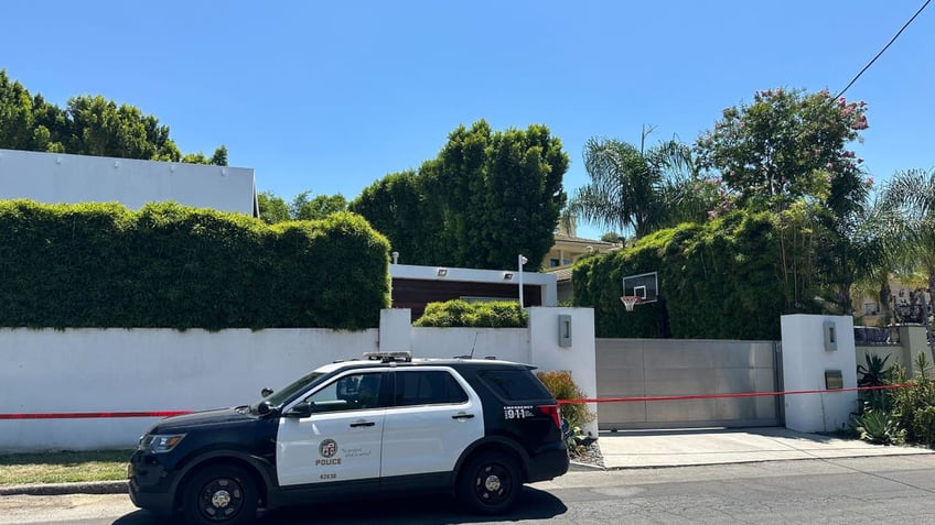 an exterior shot of robin kaye and tom deluca's house with a police car in front 