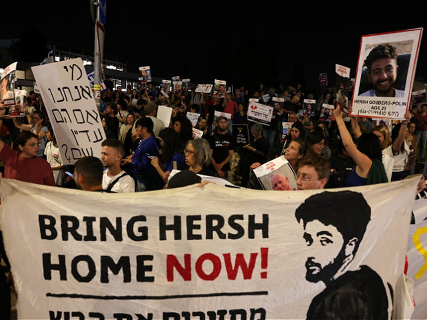 Relatives and supporters raise placards and deploy a banner bearing portraits of Israeli hostage Hersh Goldberg-Polin, 23, and other hostages held in Gaza since the October 7 attacks by Hamas in southern Israel, during a rally calling for their release, outside the PM's office in Jerusalem on May 22, 2024. (Photo by AHMAD GHARABLI / AFP) (Photo by AHMAD GHARABLI/AFP via Getty Images)