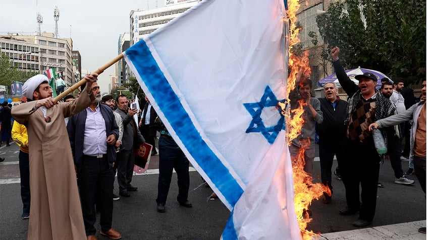 Iranian protesters burn Israeli flag