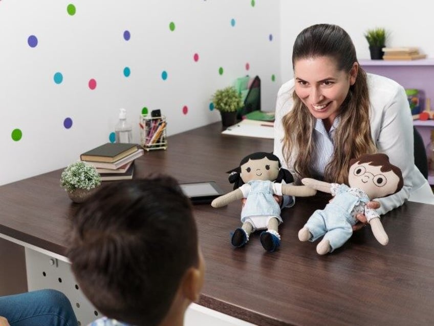 Psychologist shows child two dolls