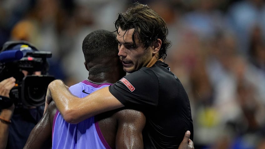 Taylor Fritz hugs Frances Tiafoe