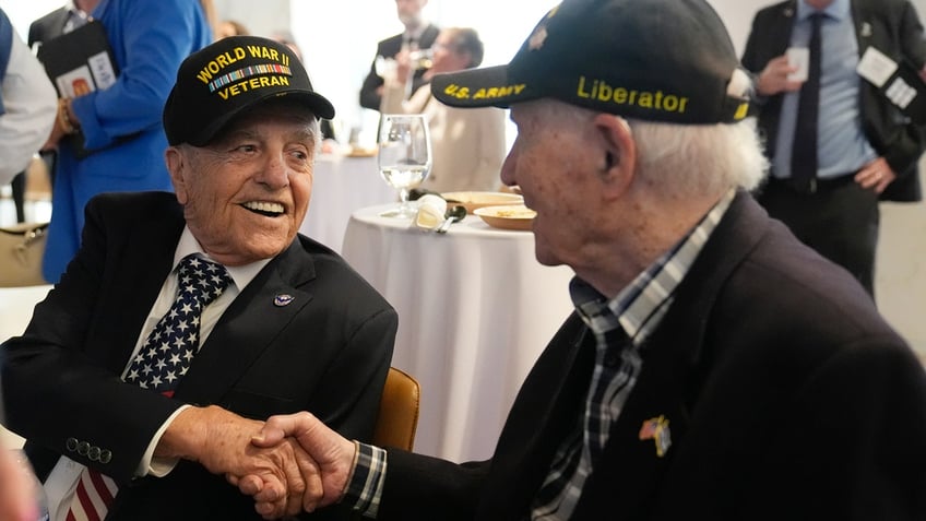 World War II veterans Andy Negra, left, and Hilbert Margol, speak to each other during an an event honoring them.