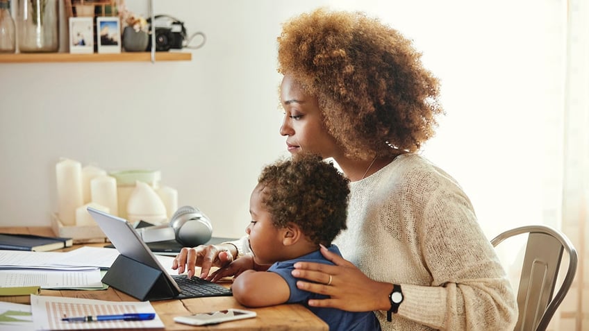 Woman sitting with son at table in kitchen