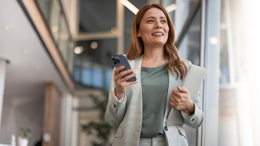 business woman with phone and portfolio in office