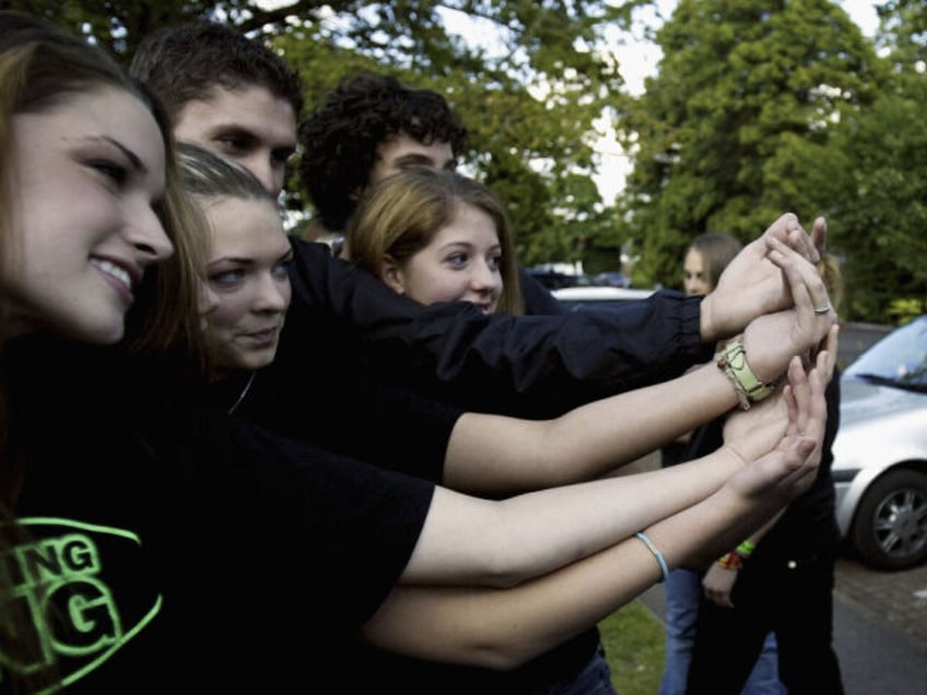 Members of the U.S. teen celibacy group Silver Ring Thing display their rings to waiting m