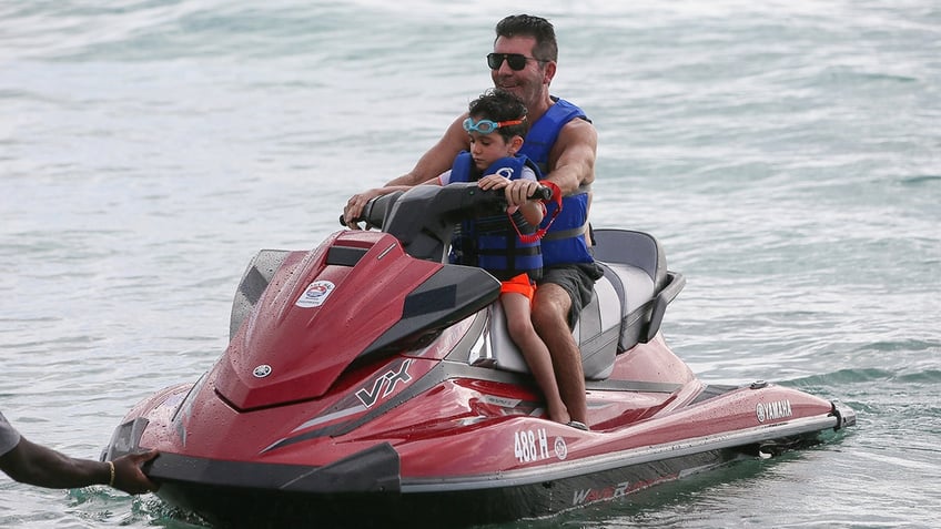 Simon Cowell riding a jet ski with son Eric